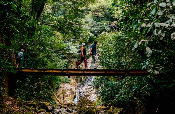 Couple walking on a hanging bridge at Sendero el Chorro