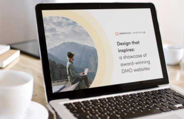 The Granicus "Design that inspires: A showcase of award-winning DMO websites," lookbook open on a laptop.