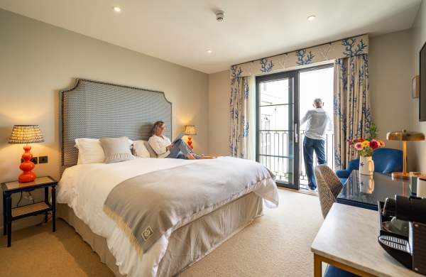 Couple lounging in hotel room with double bed
