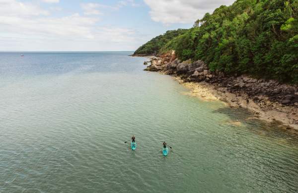 A drone shot of two people kayaking in Oxwich