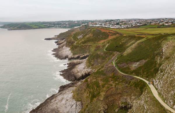 Drone shot of the rugged coastline of Gower with the coast path winding along.