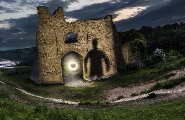 Creepy silouhette against castle at night time
