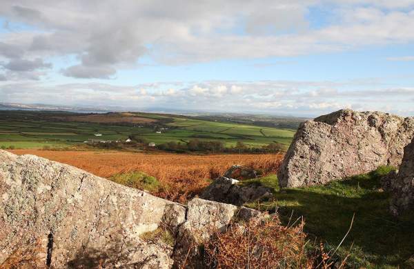 Rural Gower landscape with a rock formation in the foreground.