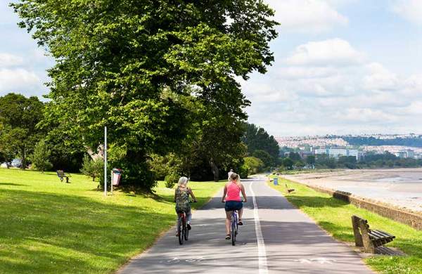 Two women cycling along the bike path on Swansea prom.