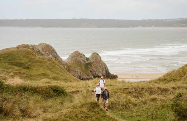 Walkers heading towards Three Cliffs Bay in the distance.