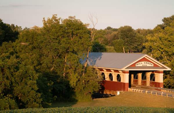 Cyclists crossing a covered wooden bridge