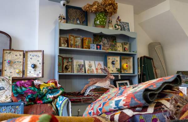a small gift shop with antiques on the wall and products in foreground