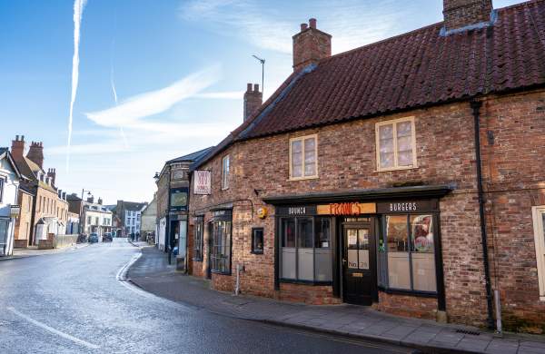 a street in horncastle with historic houses and restaurant in the foreground