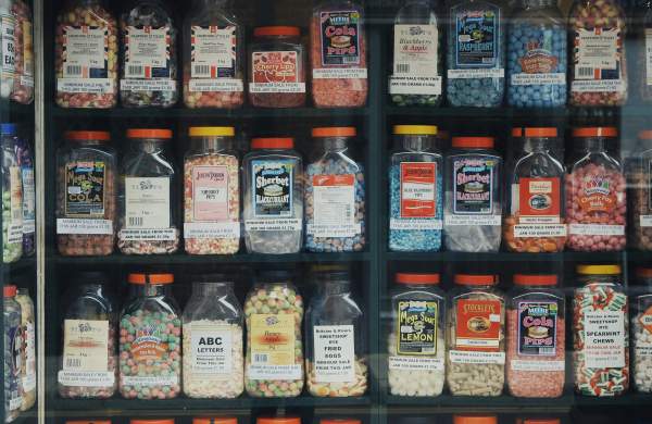 a shelf in a sweet shop with tubs of sweets
