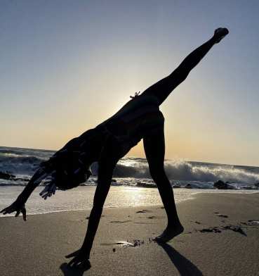 A girl cartwheels at sunset on Caspersen Beach
