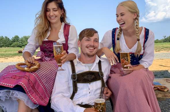 Three people enjoying beers from Wheatland Spring Farm Brewery for Oktoberfest in Loudoun County