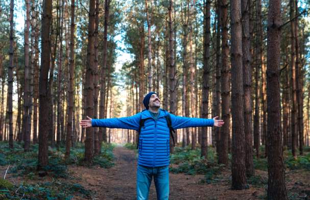 Man in forrest with wide open arms