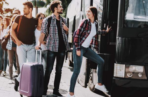 A group of individuals boarding a charter bus in Norman, Oklahoma