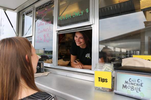 A woman orders at a food truck window.