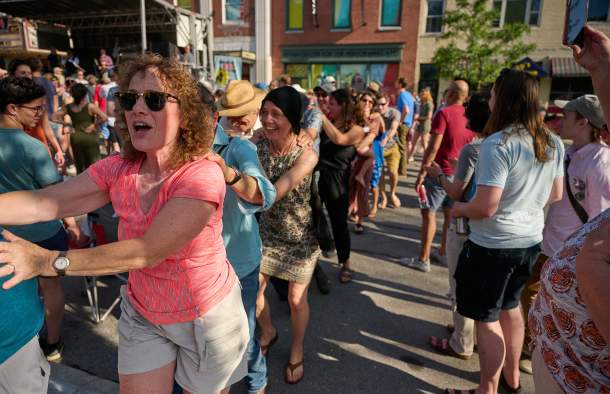 woman in pink shirt having fun in a dancing conga line at Discover Jazz Festival in Burlington VT