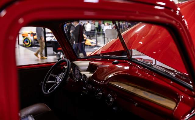 Close up through the passenger window of a cherry red old truck