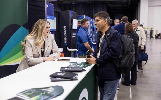 Woman and man talking to each other standing at a convention tradeshow booth table