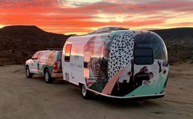 Salt Lake Branded Airstream trailer  pulled by a Salt Lake branded truck at sunset in the mountains