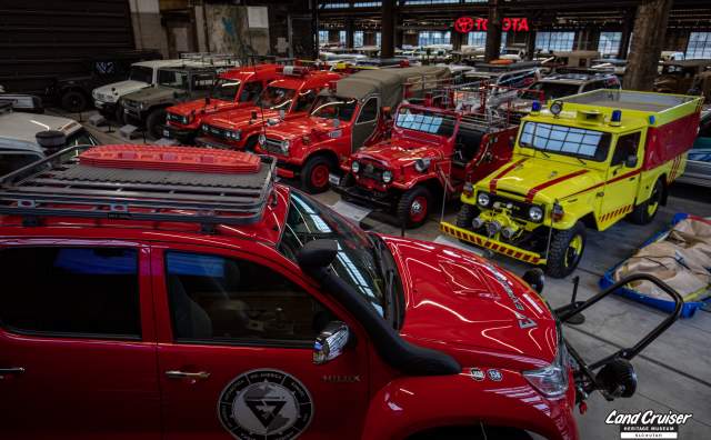 View from overhead of red and yellow vintage Land Cruiser vehicles