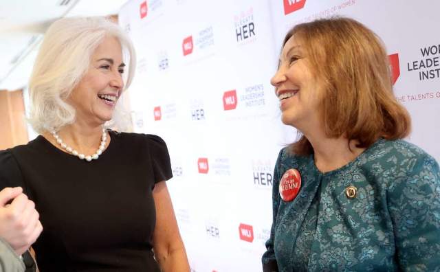 Two women speaking together, background says U Women Leadership Institute