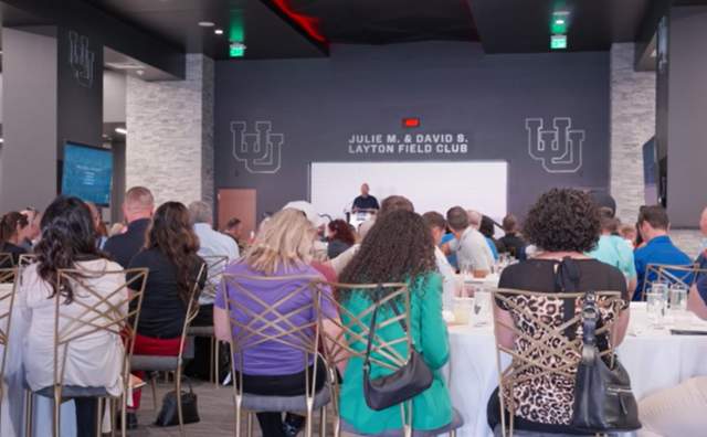 People sitting at tables listening to Clay Partain speak at Sports Tourism Summit 2022