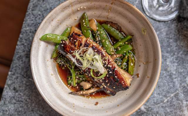 Plate of Fish with sugar snap peas and sauce at Franklin Ave Cocktails & Kitchen