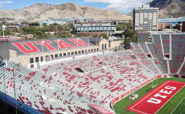 An aerial view of Rice Eccles Stadium showing the mountains in the background and the top row showing Utah and the field showing Utes
