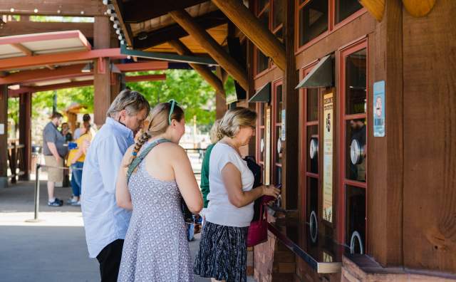 Three people standing at the Zoo ticket window showing their tickets