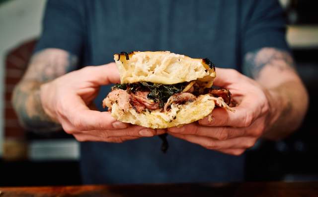 Image of a chef holding a Porchetta and Broccoli rabe at Central 9th Market