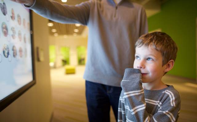 Father and son explore family photos at Family History Library
