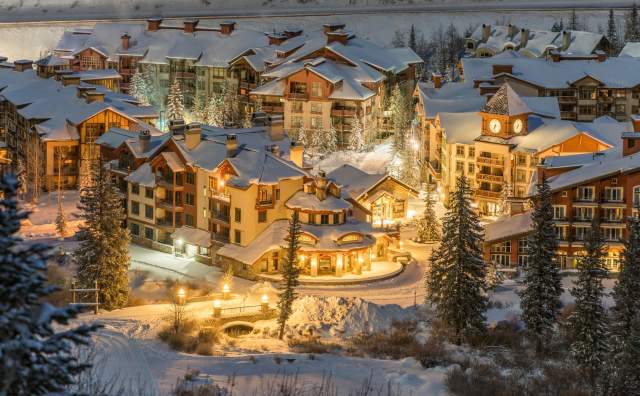 Aerial view of Solitude Village with snow on roofs and lit up with lights