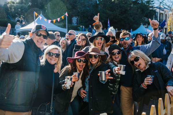 A group of people smiling at Highlands Food & Wine Festival.