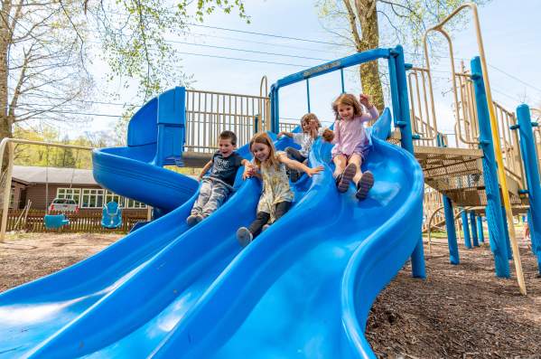 Laurelville Summer Camp Children sliding down a blue slide
