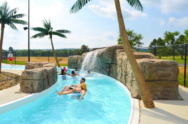Children and adults float down a cool, blue lazy river at Parrot Island Water Park in Fort Smith.