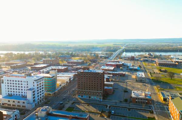 The sun peeks over the Arkansas River and bathes downtown Fort Smith in summer rays.