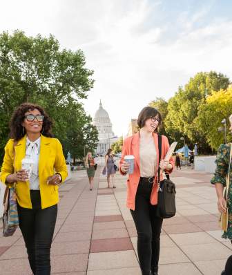 People walking towards the Monona Terrace with the Capitol Building in the background