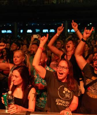 A crowd of people throw their hands up at a concert at The Sylvee