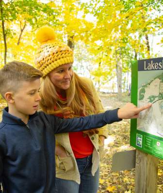 A mother and son view the Lakeshore Nature Preserve trail map