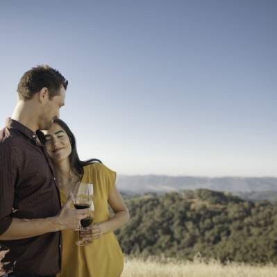Man and Woman Hugging Outdoors While Drinking Wine in Paso Robles