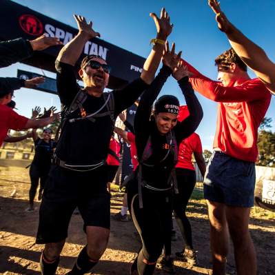 Spartan racers cheering as they cross the the finish line
