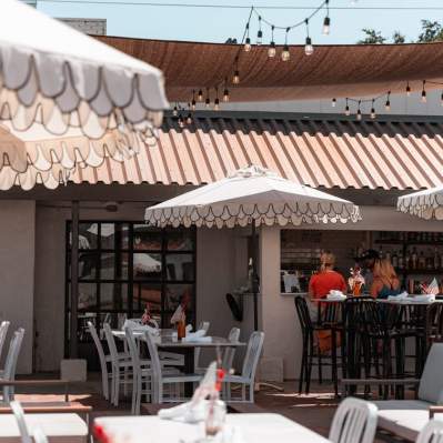 Restaurant patio with tables, chairs, umbrellas, outdoor bar and lights