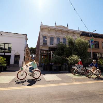 Bikers in bike lane peddling bast building skyline in downtown San Luis Obispo, CA