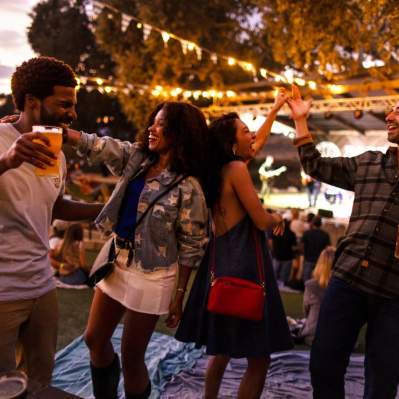 Group of friends dancing under twinkling lights at a live music venue