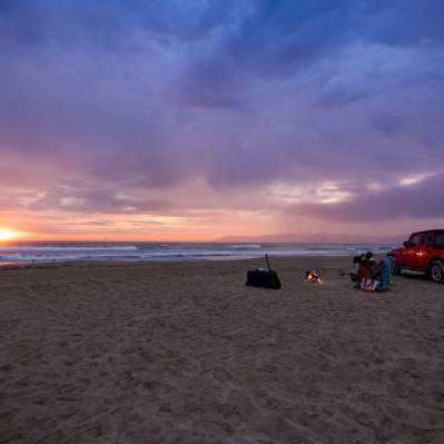 Couple having a beach bonfire in Pismo Beach, CA