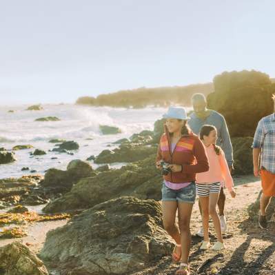 family of four exploring the tidepools near the beach