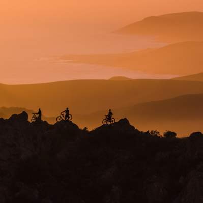 Silhouettes of mountain bikers at Cerro Alto at dusk