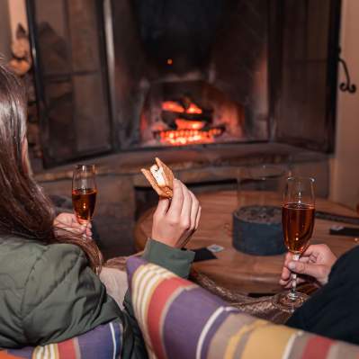 girls enjoying wine and s'mores by the fireplace at Hotel Cheval