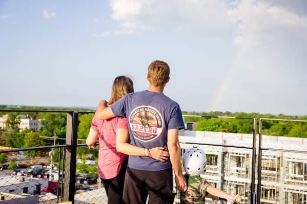Family observing rainbow off of the ledger