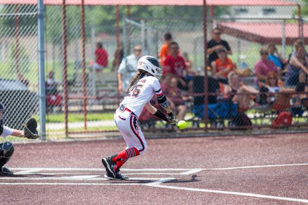 Image of a girl hitting a softball on a field