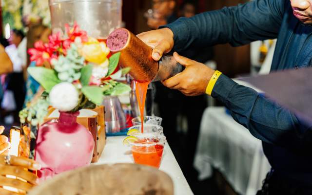 Bartender pouring a beverage from a cocktail shaker into a glass